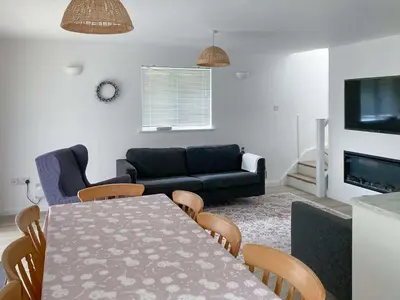 a living room with a table and a couch at Halcyons Rest in Saint Tudy