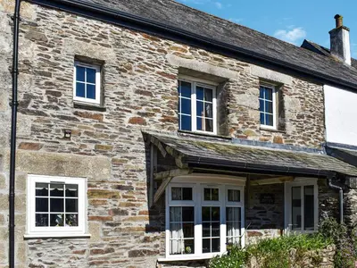 an old stone house with white windows and a porch at Barn Cottage - Uk47089 in Davidstow