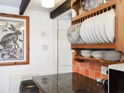 a kitchen with plates and dishes on a shelf at Barn Cottage - Uk47089 in Davidstow