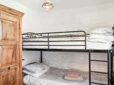 a room with three bunk beds and a closet at Barn Cottage - Uk47089 in Davidstow