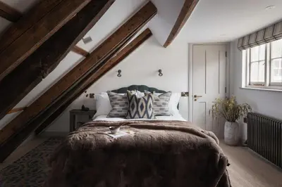a bedroom with a large bed in a attic at Kittiwake Cottage - Charming harbour-side cottage, luxury interiors in Port Isaac