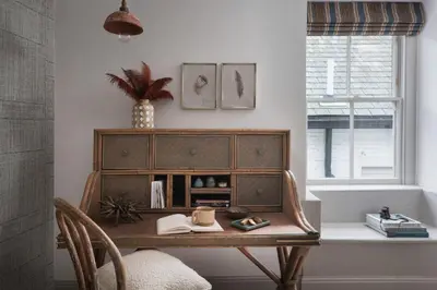 a desk with a wooden cabinet in a room with a window at Kittiwake Cottage - Charming harbour-side cottage, luxury interiors in Port Isaac