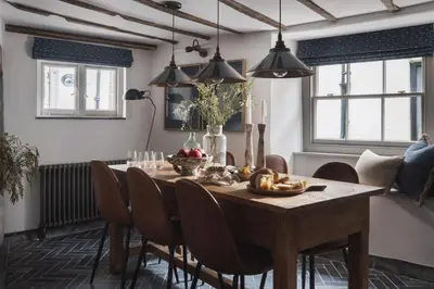 a dining room with a wooden table and chairs at Kittiwake Cottage - Charming harbour-side cottage, luxury interiors in Port Isaac
