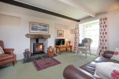 a living room with a couch and a fireplace at Barton Bothy in Porthscatho