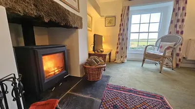 a living room with a wood burning stove at Barton Bothy in Porthscatho