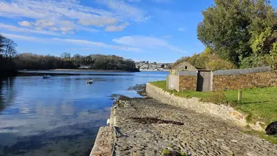 a view of a river with a building on the shore at Barton Bothy in Porthscatho