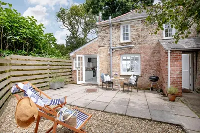 a patio in front of a brick house at Lavender Cottage in Porthscatho