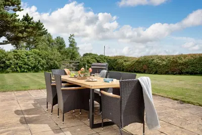 a wooden table and chairs on a patio at Meadow House in Porthscatho