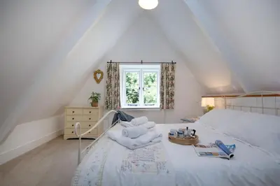 a bedroom with a white bed and a window at Place Lodge in Porthscatho