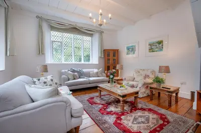 a living room with two couches and a table at Place Lodge in Porthscatho