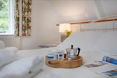 a tray with cups and a coffee maker on a bed at Place Lodge in Porthscatho