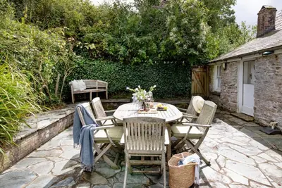 a table and chairs on a stone patio at Place Lodge in Porthscatho