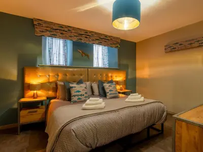 a bedroom with a bed with two towels on it at Holiday Home Tolcarne by Interhome in Newquay