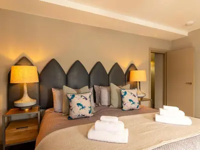 a bedroom with a large bed with two lamps at Holiday Home Tolcarne by Interhome in Newquay
