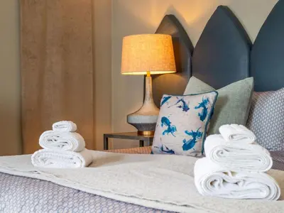 a bedroom with a bed with towels on it at Holiday Home Tolcarne by Interhome in Newquay
