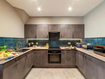 a large kitchen with stainless steel cabinets and appliances at Holiday Home Tolcarne by Interhome in Newquay