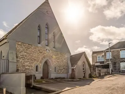 a church with a tall steeple on a street at Holiday Home Tolcarne by Interhome in Newquay