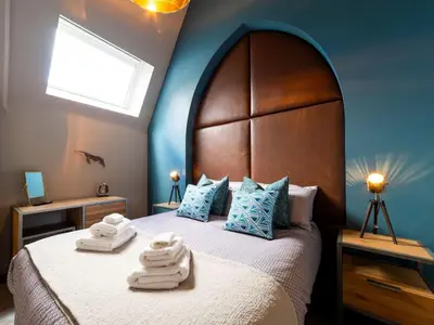 a bedroom with a large bed with towels on it at Holiday Home Tolcarne by Interhome in Newquay