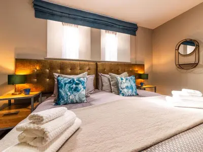 a bedroom with a large bed with blue pillows at Holiday Home Seaside House by Interhome in Newquay