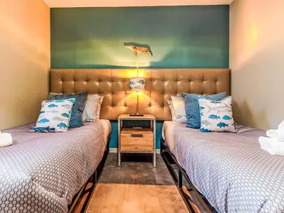 two beds in a small room with a table between them at Holiday Home Seaside House by Interhome in Newquay