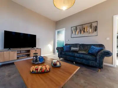 a living room with a couch and a table at Holiday Home Seaside House by Interhome in Newquay