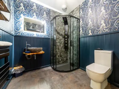 a bathroom with blue walls and a shower with a toilet at Holiday Home Seaside House by Interhome in Newquay