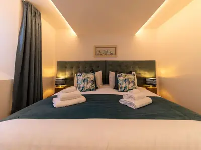 a bedroom with a large bed with towels on it at Holiday Home Sun Trap by Interhome in Newquay
