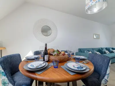 a dining room table with plates and a mirror at Holiday Home Sun Trap by Interhome in Newquay
