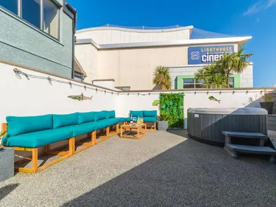 a patio with blue couches in front of a building at Holiday Home Sun Trap by Interhome in Newquay