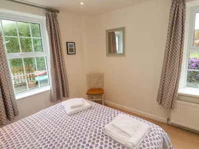 a bedroom with a bed and two windows at Fair View in Truro