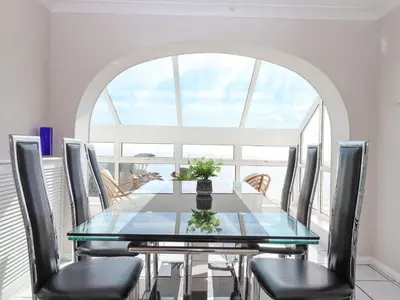 a dining room with a glass table and chairs at Seahaze in Torpoint