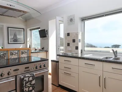 a kitchen with a stove and a sink and a window at Seahaze in Torpoint