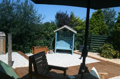 a patio with a chair and a gazebo at TREKLYS Shepherds Hut in Otterham