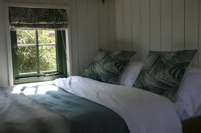a bed sitting in a room with a window at TREKLYS Shepherds Hut in Otterham