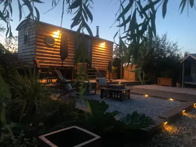 a tiny house in a garden at night at TREKLYS Shepherds Hut in Otterham