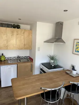 a kitchen with a wooden table and some chairs at Trees Dale Lodge in Hayle in Hayle