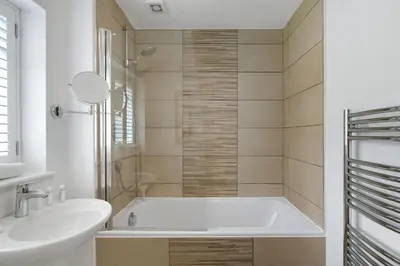 a white bathroom with a tub and a sink at The Little Hawthorns in Polzeath