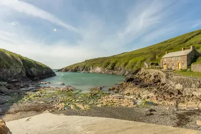 a house on the shore of a body of water at The Little Hawthorns in Polzeath
