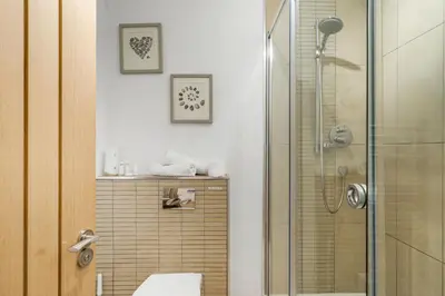 a bathroom with a shower with a glass door at The Little Hawthorns in Polzeath