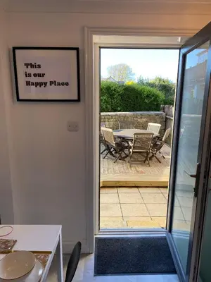 a door leading to a patio with a table and chairs at 4 Bed House in Lovely Cornish Town in Saint Columb Major