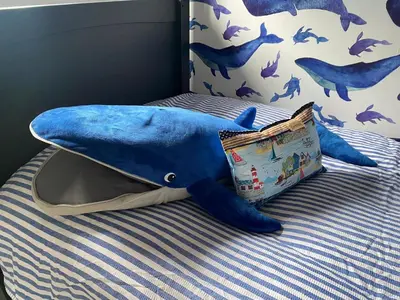 a stuffed shark on a bed with a pillow at 4 Bed House in Lovely Cornish Town in Saint Columb Major