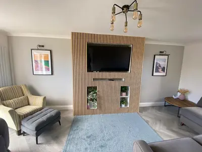a living room with a flat screen tv on a wall at 4 Bed House in Lovely Cornish Town in Saint Columb Major