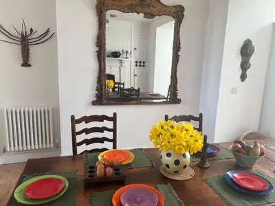 a dining room table with a mirror on the wall at The Moorings - Just a few metres from the sea! in Padstow