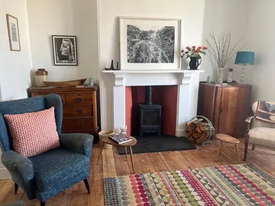 a living room with a chair and a fireplace at The Moorings - Just a few metres from the sea! in Padstow