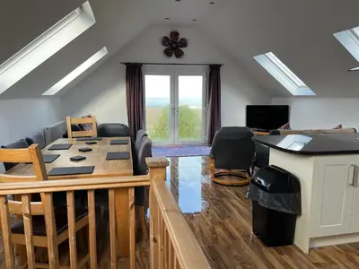 a living room with a table and chairs and a window at Sunnyridge Cottage, Porthcothan Bay in Saint Ervan