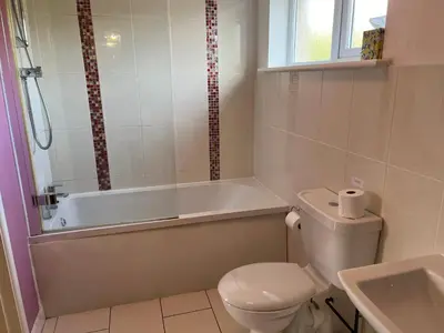 a bathroom with a toilet and a tub and a sink at Sunnyridge Cottage, Porthcothan Bay in Saint Ervan