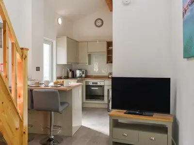 a kitchen with a desk with a television on a table at The Boat House in Padstow