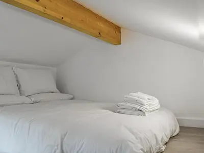 a bedroom with a bed with white sheets at The Boat House in Padstow