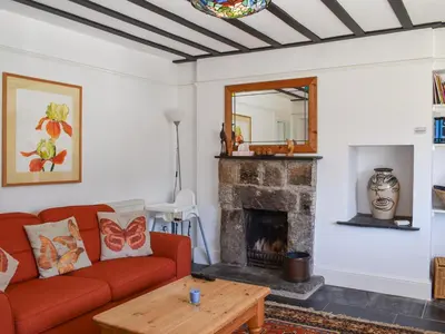 a living room with a red couch and a fireplace at Nessa Cottage - Uk47087 in Davidstow