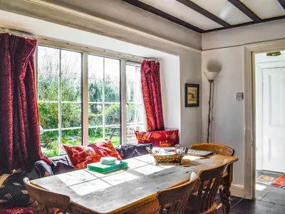 a dining room with a table and a large window at Nessa Cottage - Uk47087 in Davidstow